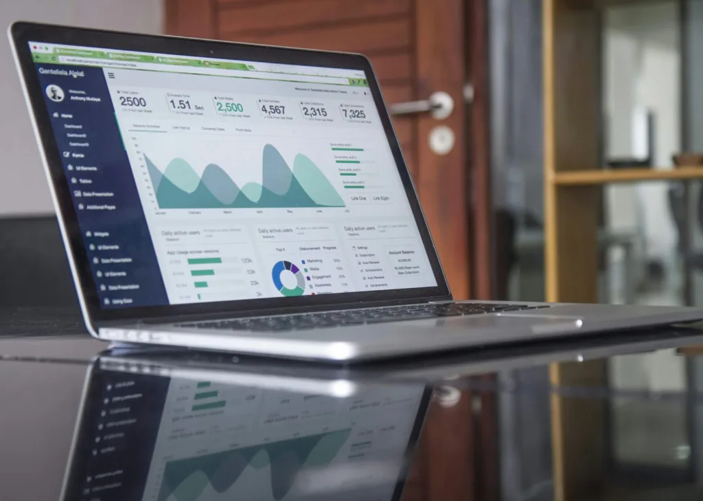 Laptop on a desk showing a web analytics dashboard with charts